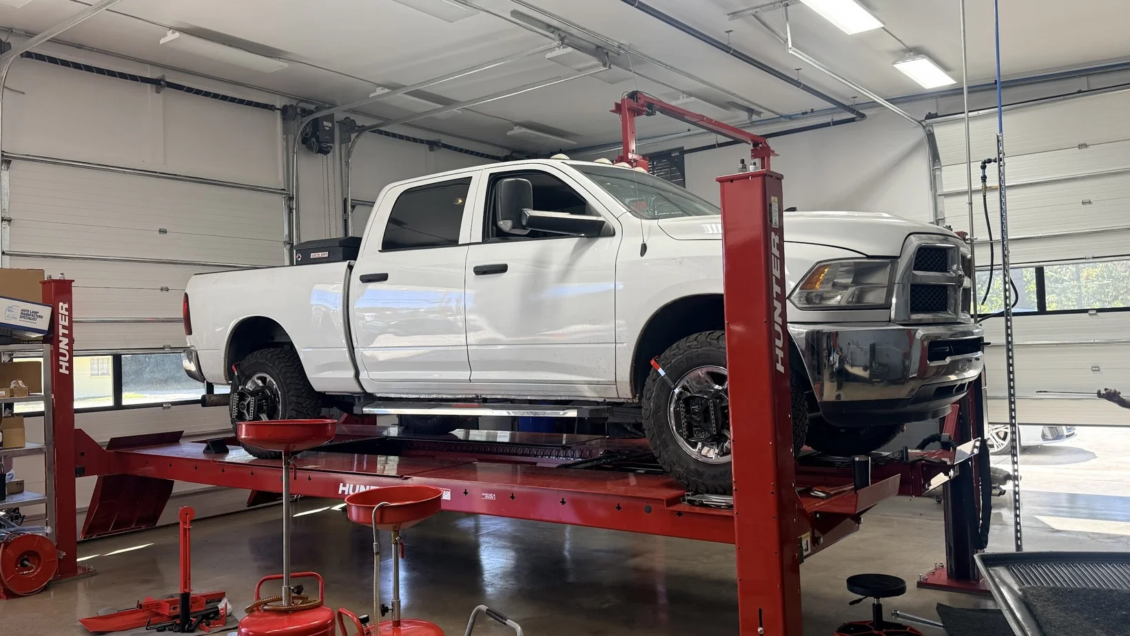 White Ram pickup on the Hunter alignment rack inside Fullbay Auto Centers